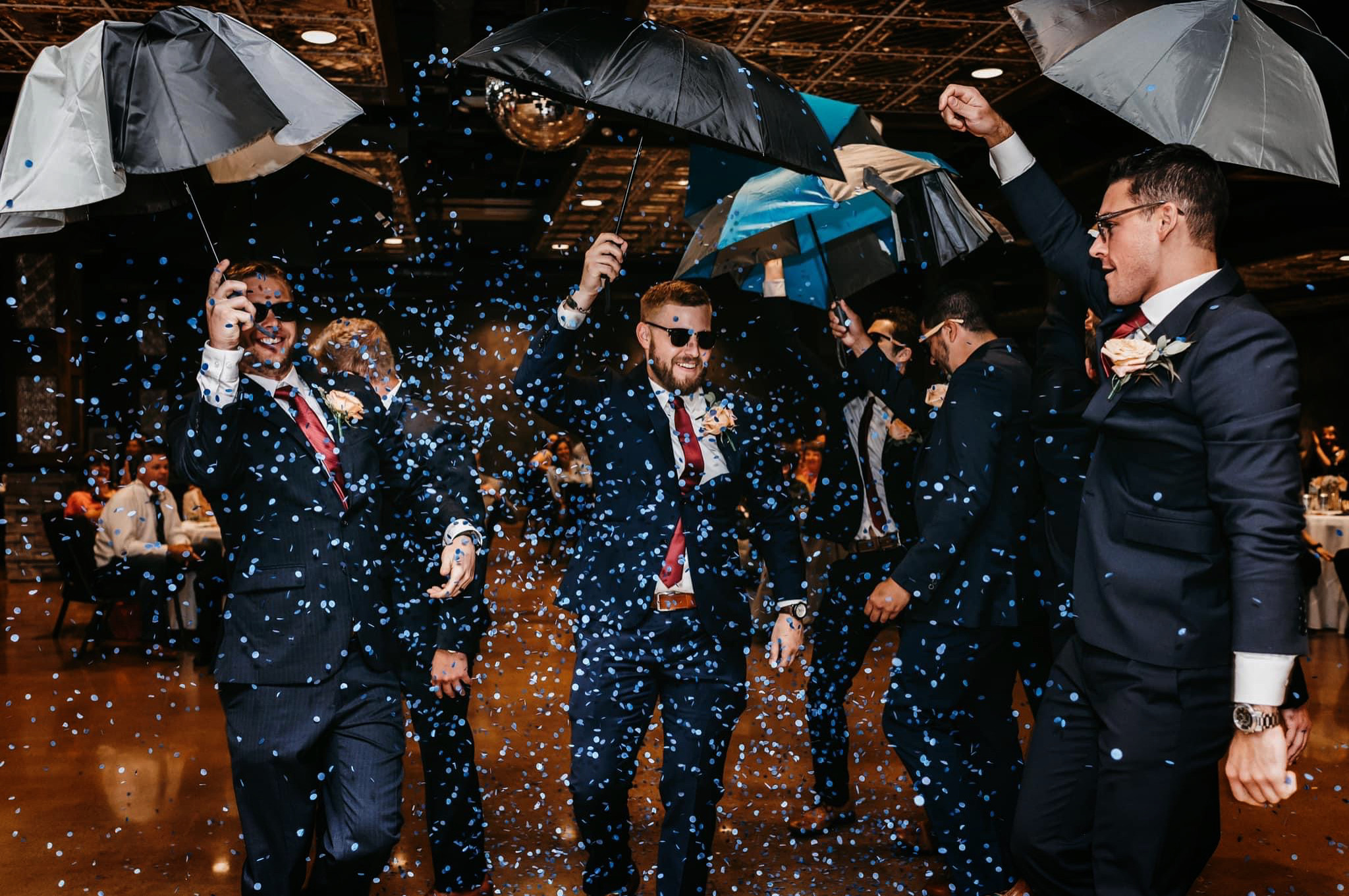 Becca and Matt's groomsmen opening confetti-filled umbrellas during their entrance at The Reverie